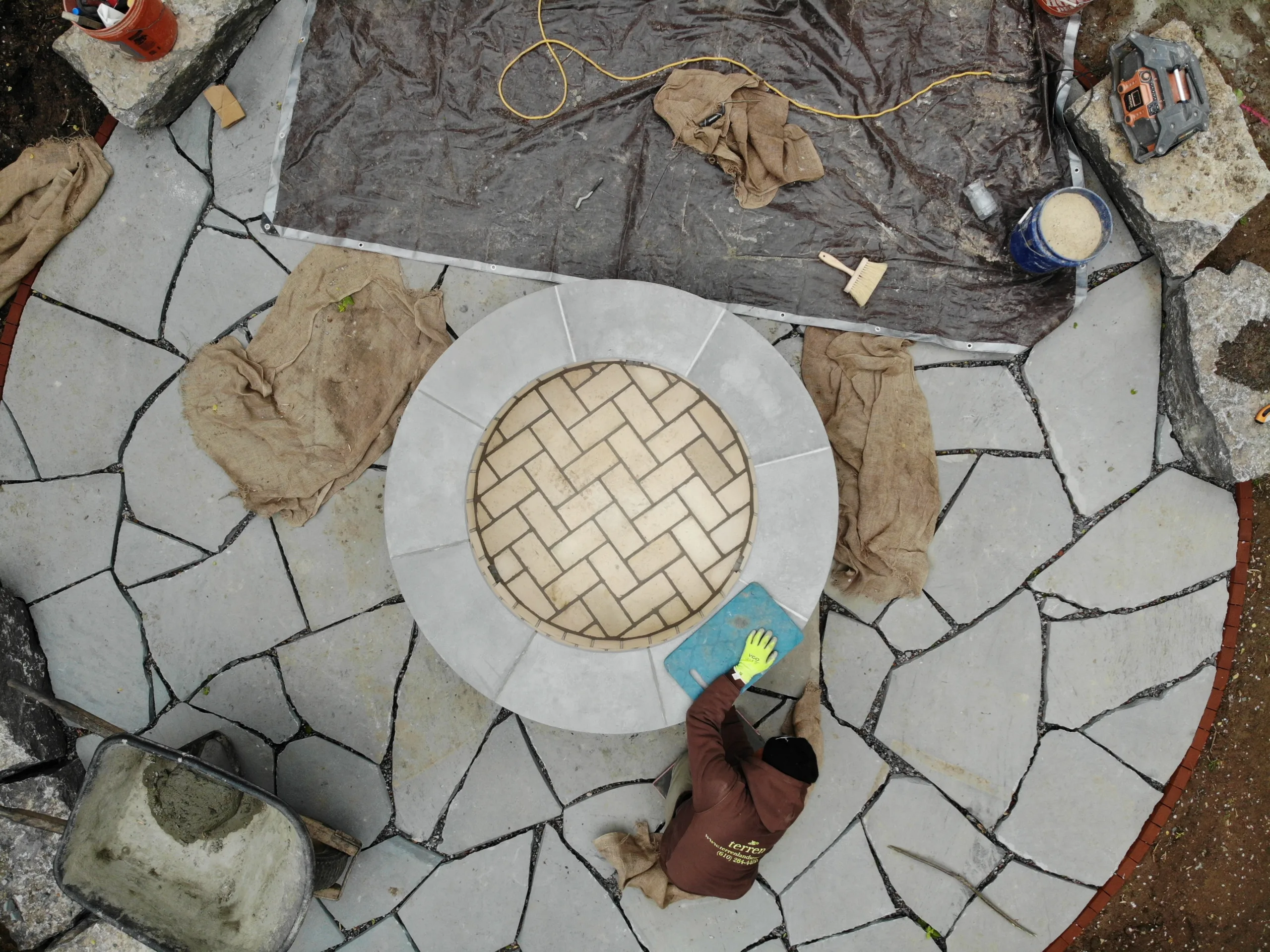 Stone Mason Working on Irregular Flagstone Fire Pit Seating Area